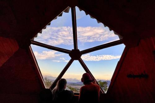 a group of people looking out of a large window at Domos El Llano in Putaendo