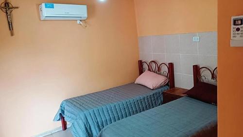 a room with two beds and a air conditioner at Departamento Eva in Deán Funes