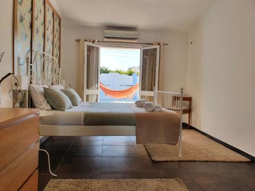 a bedroom with a bed and a large window at Moradia Familiar Piscina 5min Praia by HOST-POINT in Charneca