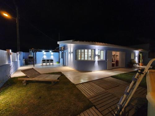 a house at night with a bench in the yard at Moradia Familiar Piscina 5min Praia by HOST-POINT in Charneca