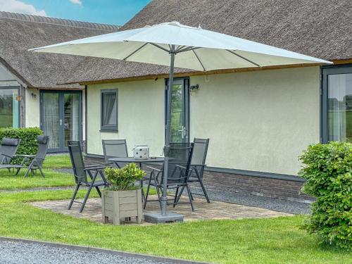 a table and chairs with an umbrella in the yard at Villa Bianco in Alphen