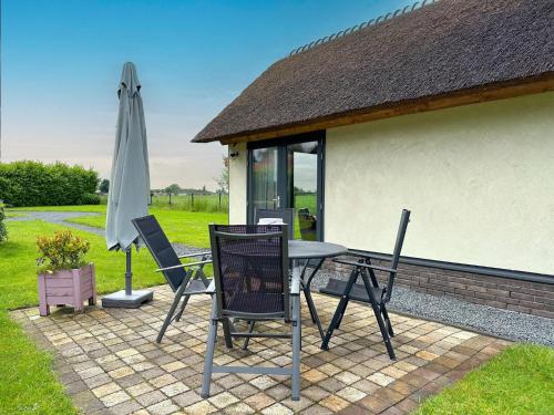 a table and chairs and an umbrella on a patio at Villa Amore in Alphen