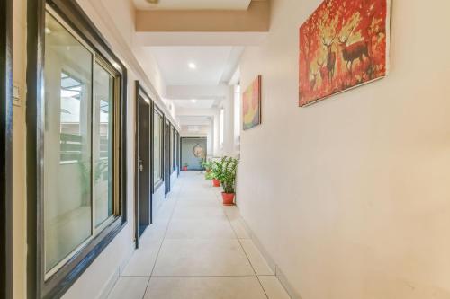 a corridor of an office building with a painting on the wall at Super Townhouse Dewas City Formerly Utsav in Dewās