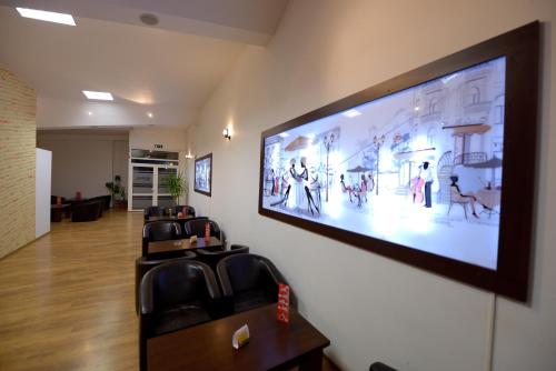 een wachtkamer met een grote flatscreen-tv aan de muur bij Hotel Sophia in Tecuci
