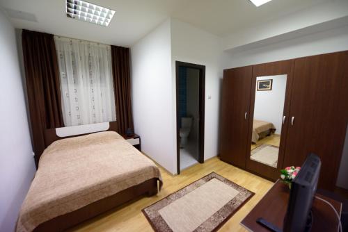 TecuciにあるHotel Sophiaの小さなベッドルーム(ベッド2台、鏡付)