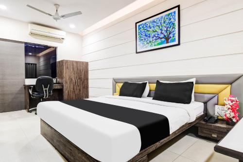 a bedroom with a bed and a desk at Super Townhouse Dewas City Formerly Utsav in Dewās