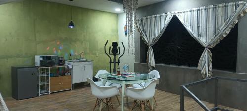ein Esszimmer mit einem Tisch und weißen Stühlen in der Unterkunft Departamento en renta in Yelateni