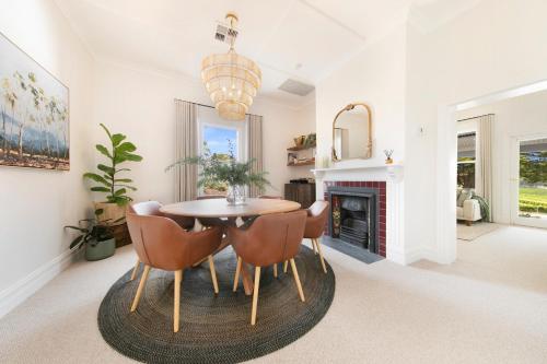 a dining room with a table and chairs and a fireplace at Adelaide Hills Luxury Cottage - The Gladys in Carey Gully