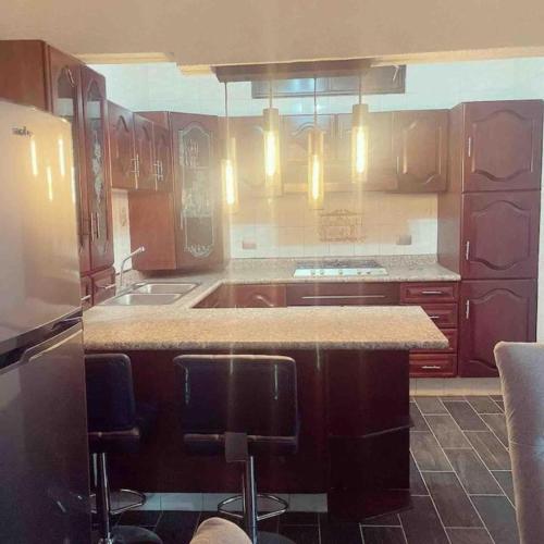 a kitchen with wooden cabinets and a counter top at Casa de 4 Habitaciones para 10 personas en el centro de la ciudad in Morelia