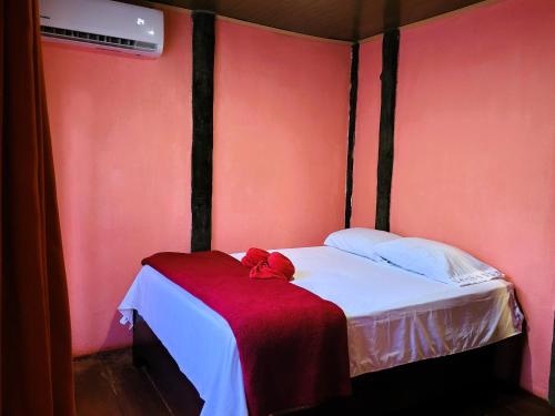 a bedroom with a bed with a red blanket on it at Chalets Silencio del Bosque in Fortuna