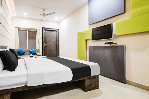 a bedroom with a bed and a flat screen tv at Super Townhouse Dewas City Formerly Utsav in Dewās