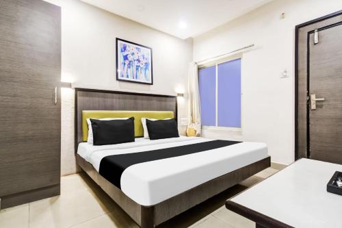 a bedroom with a large bed in a room at Super Townhouse Dewas City Formerly Utsav in Dewās
