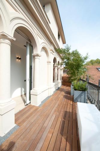 a porch of a building with a wooden deck at I Portici Hotel Bologna in Bologna