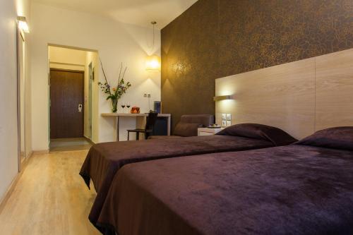 um quarto de hotel com duas camas e uma secretária em Rotonda Hotel em Tessalónica