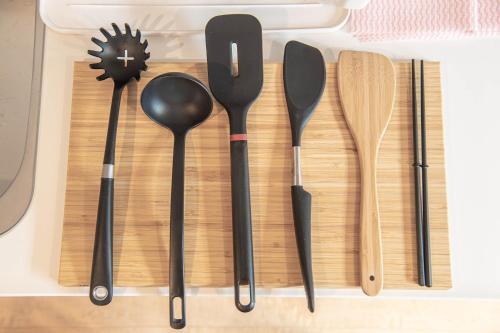 a group of spoons and spatulas sitting on a cutting board at Ocean Front Villa Katsuura やどかり in Kawazu