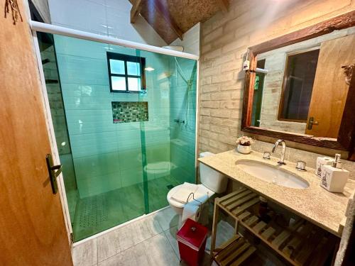 a bathroom with a shower and a sink and a toilet at Chalé na Montanha - Charme e Natureza in Santo Antônio do Pinhal