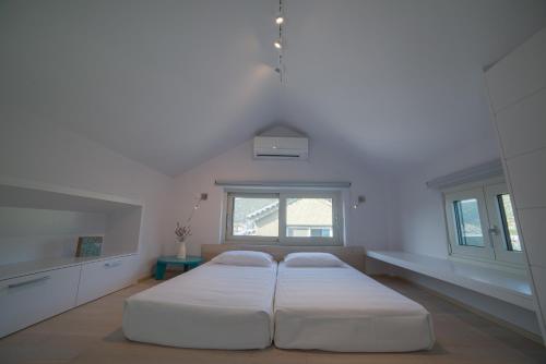 a bedroom with two beds and a window at Lavender Cove in Korfos