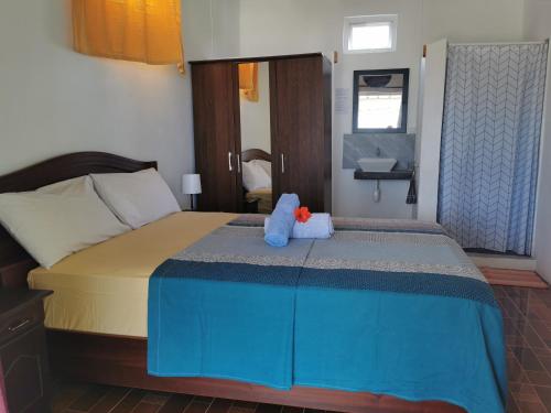 a bedroom with a bed with a blue stuffed animal on it at Hebergement Vue Sur Mer in Rodrigues Island