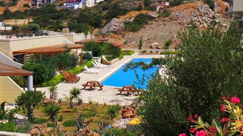a resort with a swimming pool and a mountain at Lagada Resort in Makry Gialos