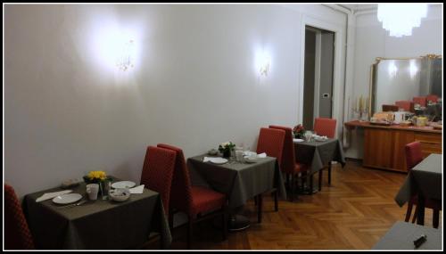 jadalnia z 2 stołami i czerwonymi krzesłami w obiekcie B&B Piazza Goldoni w Trieście