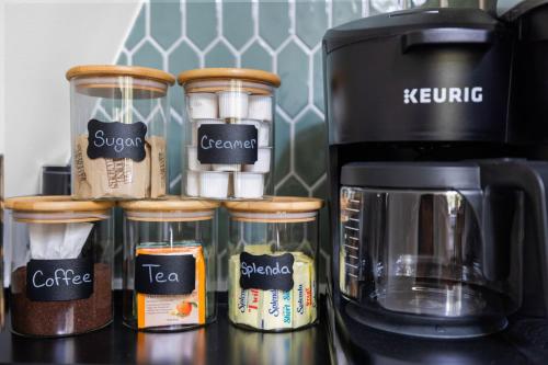 a group of coffee jars on a counter next to a coffee maker at Unique A Frame, Hot Tub, Fire Pit, Cold Plunge in Berkeley Springs