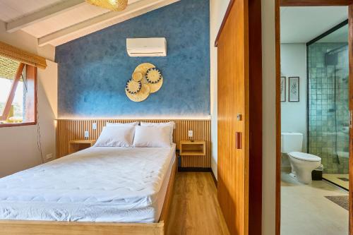 ein Schlafzimmer mit einem Bett und einer blauen Wand in der Unterkunft Bahasa Itagua in Ubatuba