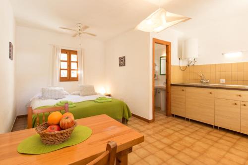 a room with a bed and a table with a bowl of fruit at Residence Can Confort Formentera in Sant Francesc Xavier