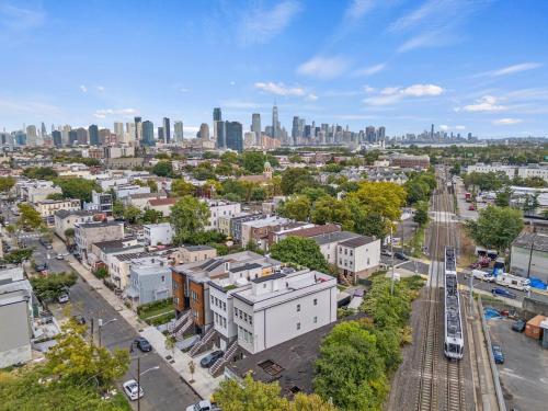 an aerial view of a city with a train at Sky High Retreat near NYC with Rooftop! in Jersey City