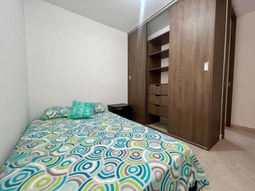 a bedroom with a bed and a wooden cabinet at Apartamento con vista a las Montañas in Ibagué