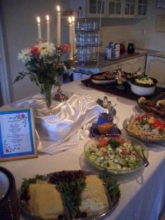 a table with several plates of food on it at Maalaiskartano Pihkala in Kestilä
