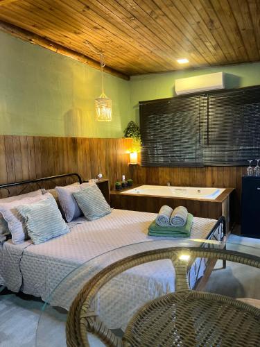 a bedroom with a large bed with pillows on it at Mandala Camping Pousada in Florianópolis