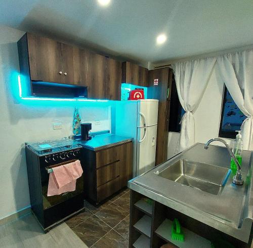 a kitchen with a sink and a stove and a refrigerator at Apartamento en Jardín Antioquia in Jardin