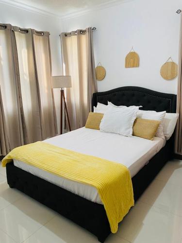 a bedroom with a bed with a yellow blanket on it at Metcalfe Two Bedroom Suite in Kingston