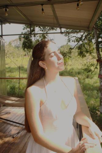 a woman in a white dress standing on a deck at Rincón Sereno San Carlos in La Marina