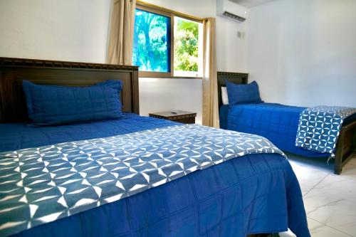 a bedroom with two blue beds and a window at Villa Pravda Paradise Guerra in La Caoba