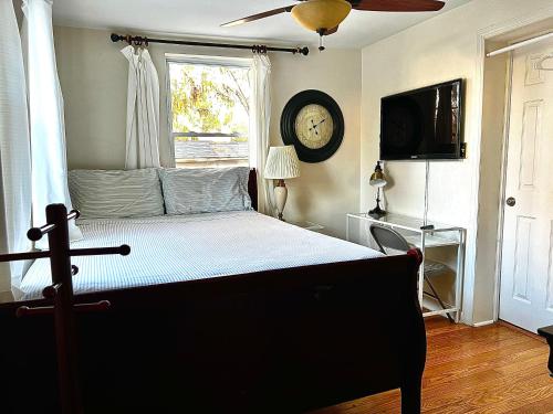 a bedroom with a bed with a clock on the wall at Aloha Homestay Falls Church in Falls Church