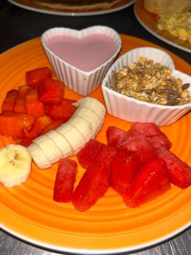 a plate of food with fruit and nuts and a heart at Ceiba lodge in Drake