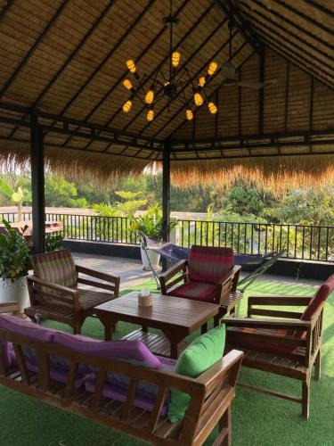 a group of chairs and tables under a pavilion at Enchanted Pool Bungalows Siem Reap, right near the Wake Park in Phumĭ Kruŏs