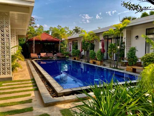 a swimming pool in front of a house at Enchanted Pool Bungalows Siem Reap, right near the Wake Park in Phumĭ Kruŏs