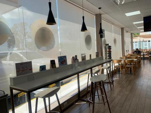 a restaurant with a bar with stools and tables at Dormis Sinsacate in Sinsacate