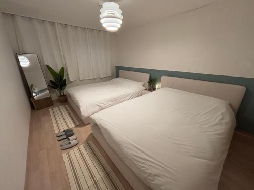 2 posti letto in una piccola stanza con lenzuola bianche di 7pp aloha stay OlympicPark KSPO JYP LotteWorld a Seul