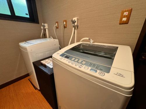 a washing machine and a washer in a room at Pension Kobekko in Otari