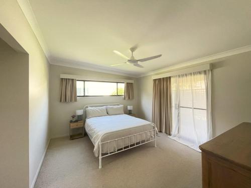 CopacabanaにあるSandy Feet Beach Houseのベッドと天井扇風機のある寝室