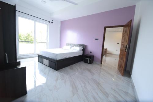 a bedroom with a bed and a large window at Blackpool Complex - Lavender in Trincomalee
