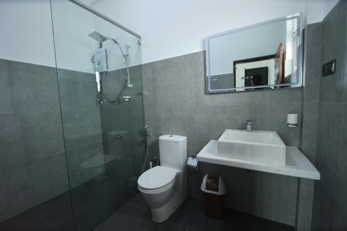 a bathroom with a toilet and a sink and a shower at Blackpool Complex - Lavender in Trincomalee
