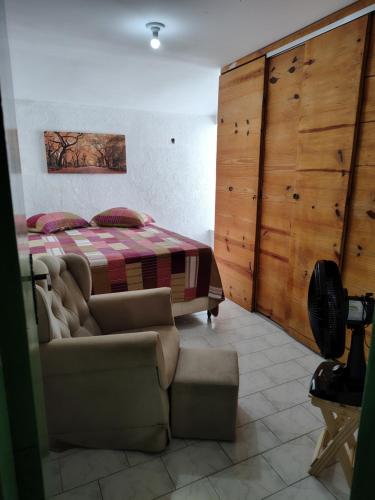 a bedroom with a bed and a couch and a bed at Suite para casal in Natal