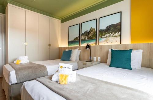 two beds in a hotel room with windows at Flat na Barra da Tijuca-G 1408-3 in Rio de Janeiro