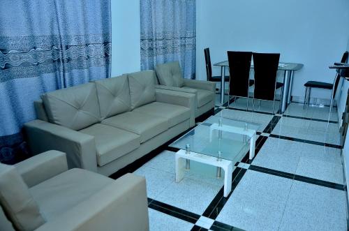 a living room with a couch and a glass table at Gosen House Zanguéra in Ablogbé