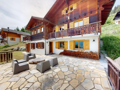 a house with a stone patio in front of it at Beautiful chalet in Le Bouveret with garden in Hérémence