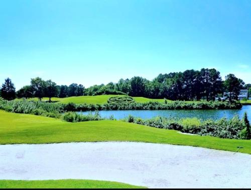 a view of a golf course with a pond at Beautiful home in Chesapeake in Chesapeake